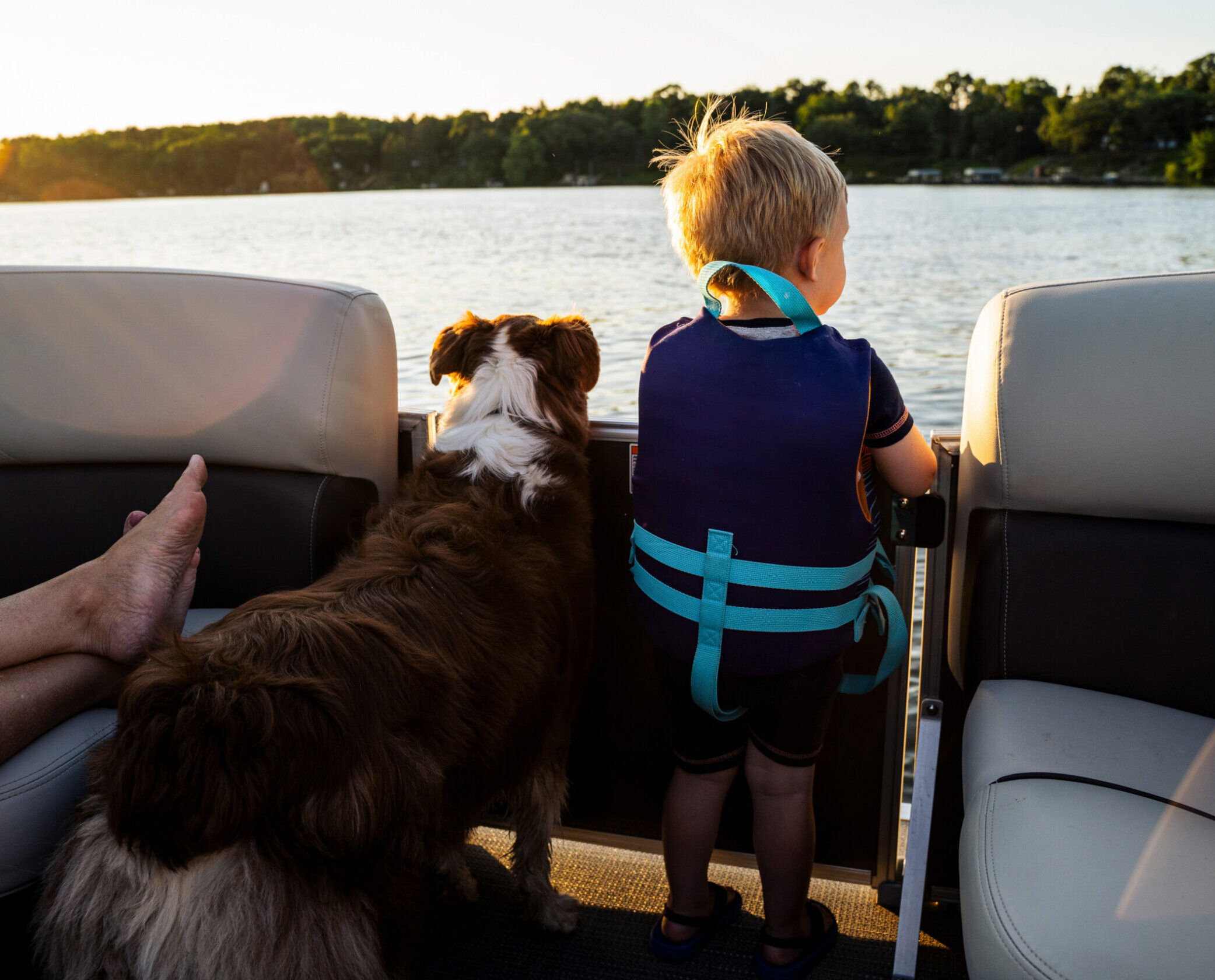 A boy and his dog on a pontoon boat on Lake Lanier