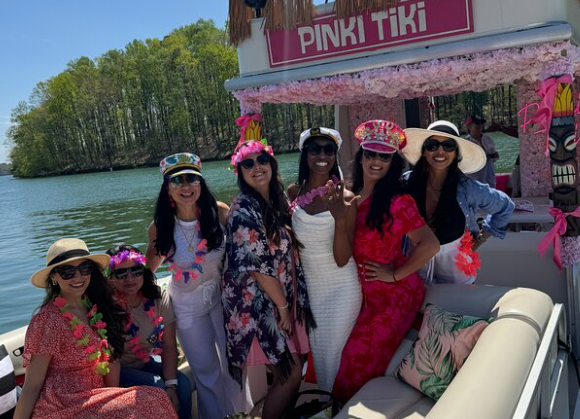 Guests aboard a pink Tiki Time boat on Lake Lanier